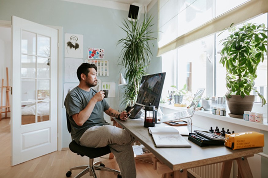 Digital artist contemplates during coffee break in his home office