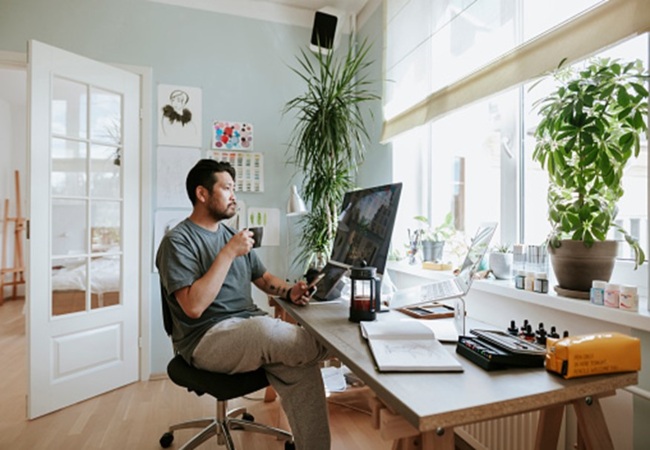 A Man at a Desk with a Computer, Surrounded by the Comforts of a Rental Apartment in Lansing, Mi 